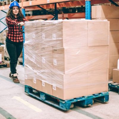 Woman shifting a loaded pallet